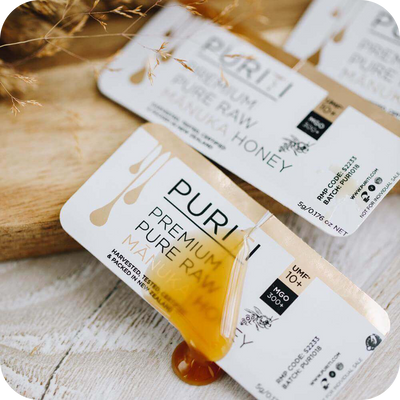 novita SG's PURITI Manuka Honey Snap Packs UMF10+ | MGO 300 on a wooden table.