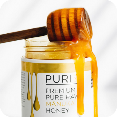 A high-end PURITI jar of pure raw manuka honey with a wooden stick, known for its exceptional purity. (Brand: novita SG)