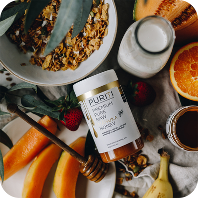 A bowl of granola, oranges, bananas and PURITI Premium Raw Manuka Honey UMF 15+ | MGO 550 from the brand novita SG.