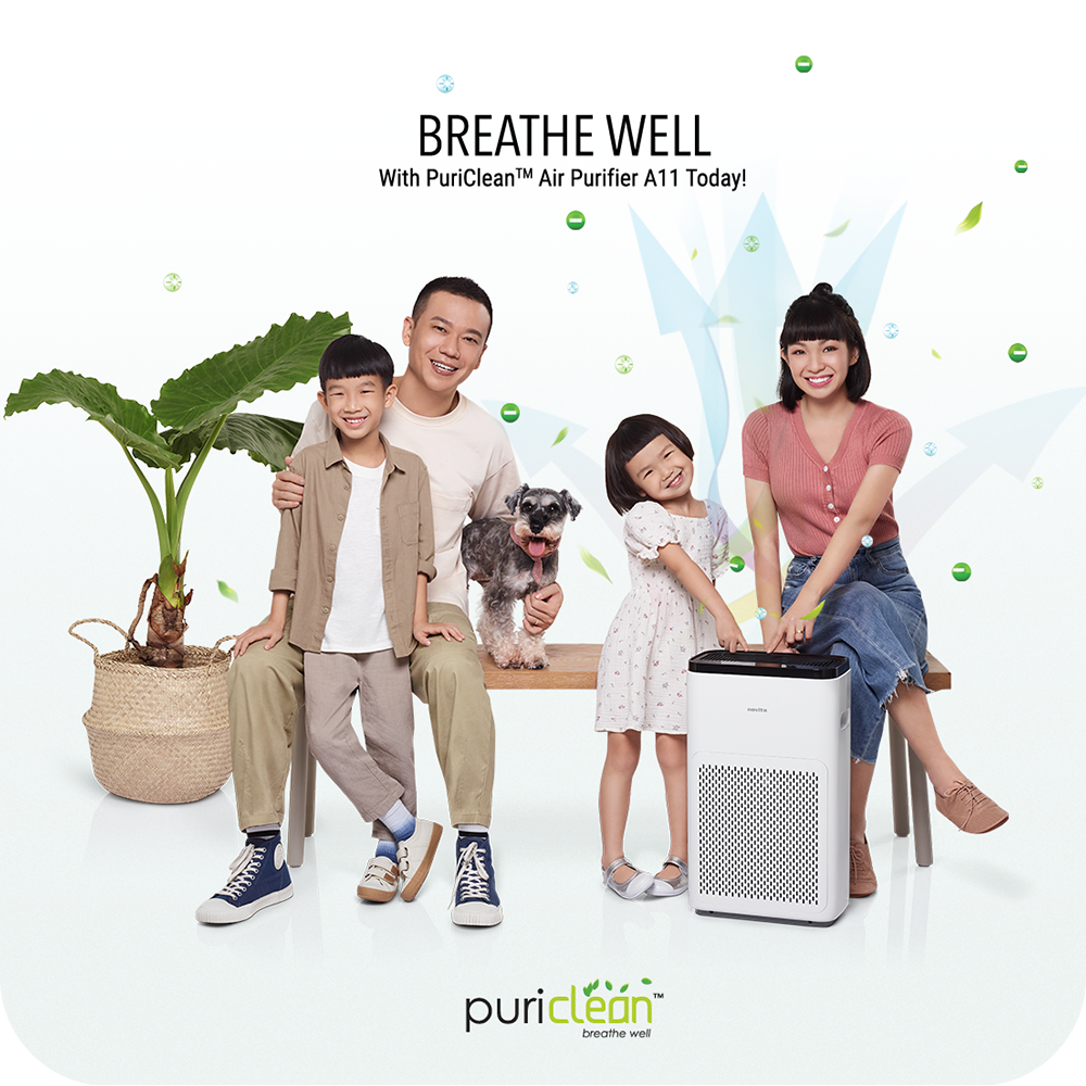 A family is posing in front of a novita Air Purifier A11 Bundle Twin Pack.