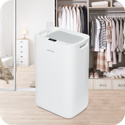 Novita Dehumidifier + Air Purifier The 2-In-1 ND25.5 in a room with clothes.