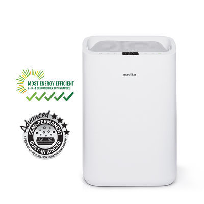 A white novita Dehumidifier + Air Purifier The 2-In-1 ND25.5 with a basket of towels next to it.