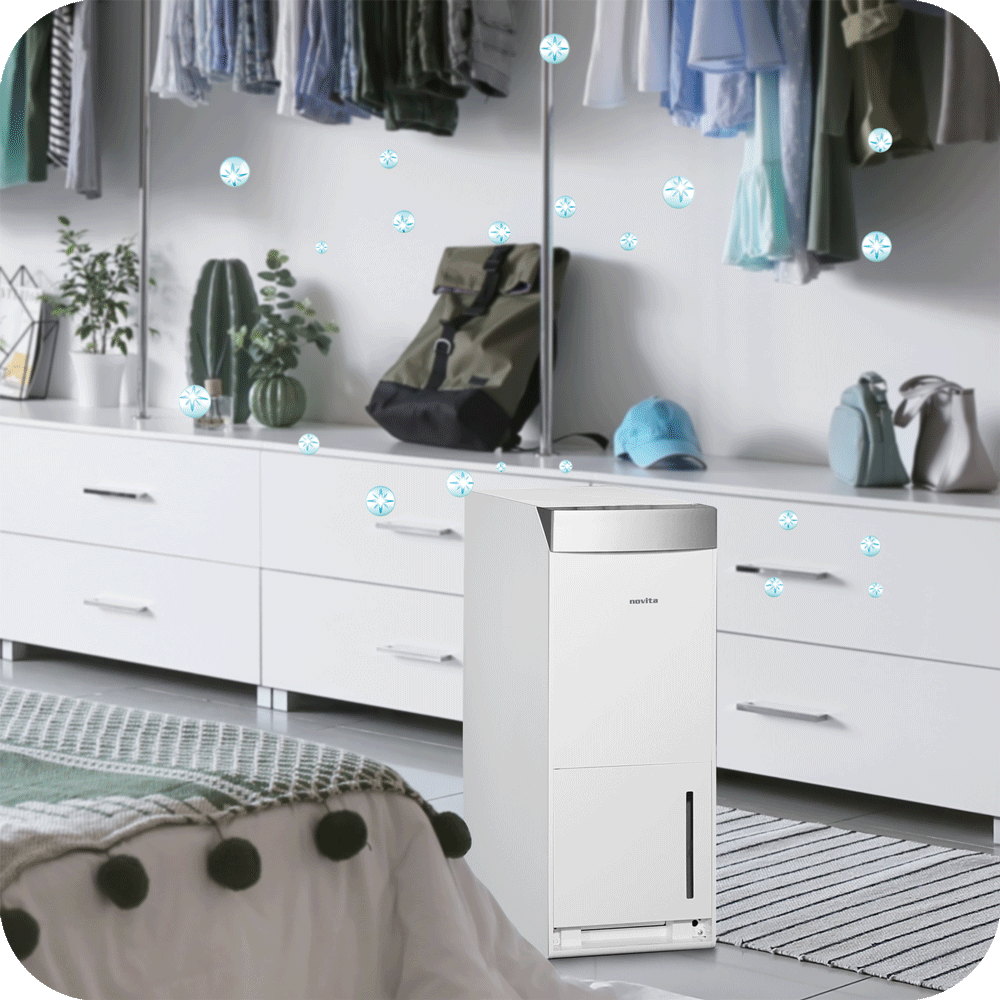 A novita Dehumidifier ND388 in a bedroom with clothes hanging in front of it. The Dehumidifier ND388 is compact and powerful, efficiently removing airborne pollutants and allergens from the room. It features a quiet operation.