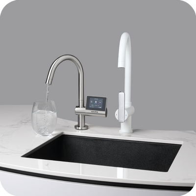 A kitchen sink with a novita HydroPlus® Premium Undersink Water Ionizer NP12000 faucet and a glass of water.