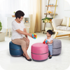 A woman playing with a baby on a colorful novita B9 stool.