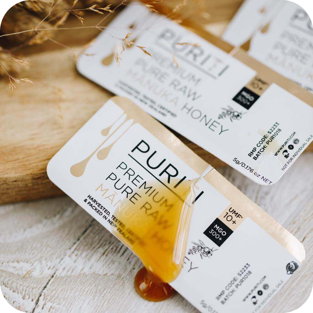 novita SG's PURITI Manuka Honey Snap Packs UMF10+ | MGO 300 on a wooden table.