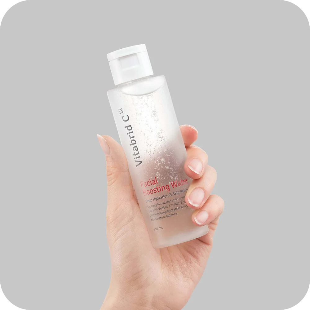 A hand holding a bottle of Vitabrid C¹² Facial Boosting Water toner.